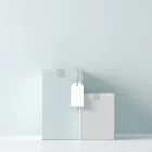 Kolme pinottua muuttolaatikkoa vaaleansinisissä ja harmaissa sävyissä, hintalappu keskimmäisessä laatikossa, minimalistinen tyyli, valkoisella taustalla.